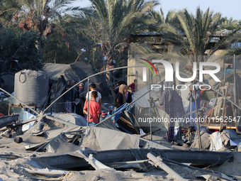 People inspect the site following Israeli strikes on a tent camp sheltering displaced people amid the Israel-Hamas conflict in the Al-Mawasi...