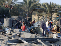 People inspect the site following Israeli strikes on a tent camp sheltering displaced people amid the Israel-Hamas conflict in the Al-Mawasi...