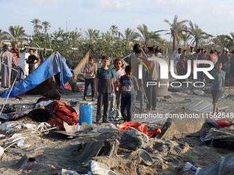 People inspect the site following Israeli strikes on a tent camp sheltering displaced people amid the Israel-Hamas conflict in the Al-Mawasi...