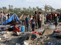 People inspect the site following Israeli strikes on a tent camp sheltering displaced people amid the Israel-Hamas conflict in the Al-Mawasi...