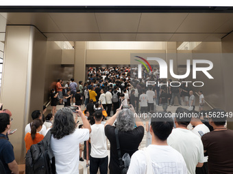 Customers experience the world's first triple foldable screen phone Mate XT just released by Huawei at its flagship store in Shanghai, China...