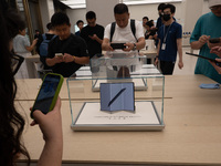 Customers experience the world's first triple foldable screen phone Mate XT just released by Huawei at its flagship store in Shanghai, China...