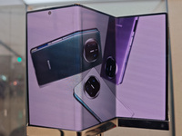 Customers experience the world's first triple foldable screen phone Mate XT just released by Huawei at its flagship store in Shanghai, China...