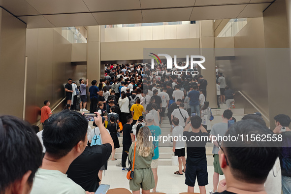 Customers experience the world's first triple foldable screen phone Mate XT just released by Huawei at its flagship store in Shanghai, China...