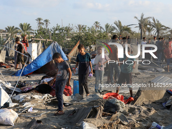 People inspect the site following Israeli strikes on a tent camp sheltering displaced people amid the Israel-Hamas conflict in the Al-Mawasi...