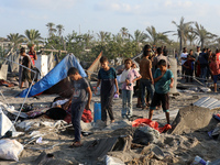 People inspect the site following Israeli strikes on a tent camp sheltering displaced people amid the Israel-Hamas conflict in the Al-Mawasi...