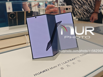 Customers experience the world's first triple foldable screen phone Mate XT just released by Huawei at its flagship store in Shanghai, China...