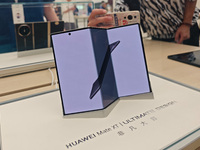 Customers experience the world's first triple foldable screen phone Mate XT just released by Huawei at its flagship store in Shanghai, China...