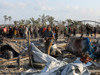 People inspect the site following Israeli strikes on a tent camp sheltering displaced people amid the Israel-Hamas conflict in the Al-Mawasi...