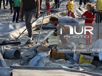 People inspect the site following Israeli strikes on a tent camp sheltering displaced people amid the Israel-Hamas conflict in the Al-Mawasi...