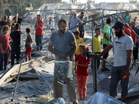 People inspect the site following Israeli strikes on a tent camp sheltering displaced people amid the Israel-Hamas conflict in the Al-Mawasi...