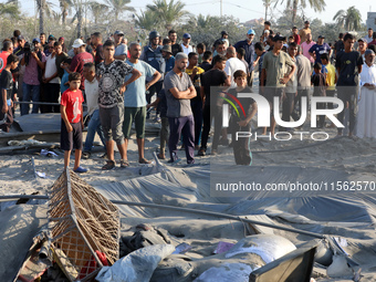 People inspect the site following Israeli strikes on a tent camp sheltering displaced people amid the Israel-Hamas conflict in the Al-Mawasi...