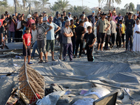 People inspect the site following Israeli strikes on a tent camp sheltering displaced people amid the Israel-Hamas conflict in the Al-Mawasi...