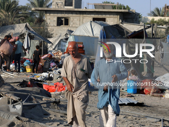 People inspect the site following Israeli strikes on a tent camp sheltering displaced people amid the Israel-Hamas conflict in the Al-Mawasi...