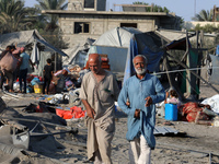 People inspect the site following Israeli strikes on a tent camp sheltering displaced people amid the Israel-Hamas conflict in the Al-Mawasi...