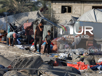 People inspect the site following Israeli strikes on a tent camp sheltering displaced people amid the Israel-Hamas conflict in the Al-Mawasi...