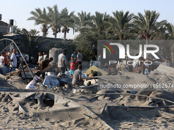 People inspect the site following Israeli strikes on a tent camp sheltering displaced people amid the Israel-Hamas conflict in the Al-Mawasi...