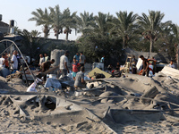 People inspect the site following Israeli strikes on a tent camp sheltering displaced people amid the Israel-Hamas conflict in the Al-Mawasi...