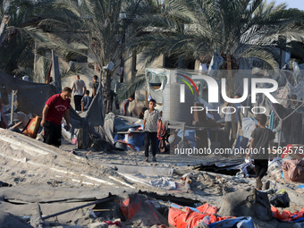 People inspect the site following Israeli strikes on a tent camp sheltering displaced people amid the Israel-Hamas conflict in the Al-Mawasi...