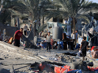 People inspect the site following Israeli strikes on a tent camp sheltering displaced people amid the Israel-Hamas conflict in the Al-Mawasi...