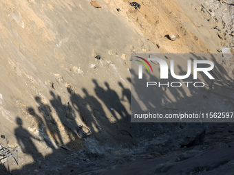 People inspect the site following Israeli strikes on a tent camp sheltering displaced people amid the Israel-Hamas conflict in the Al-Mawasi...