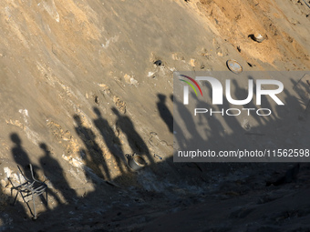 People inspect the site following Israeli strikes on a tent camp sheltering displaced people amid the Israel-Hamas conflict in the Al-Mawasi...