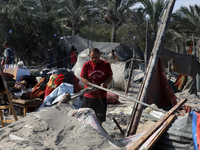 People inspect the site following Israeli strikes on a tent camp sheltering displaced people amid the Israel-Hamas conflict in the Al-Mawasi...