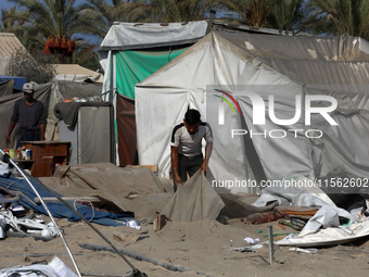 People inspect the site following Israeli strikes on a tent camp sheltering displaced people amid the Israel-Hamas conflict in the Al-Mawasi...