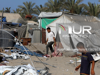 People inspect the site following Israeli strikes on a tent camp sheltering displaced people amid the Israel-Hamas conflict in the Al-Mawasi...