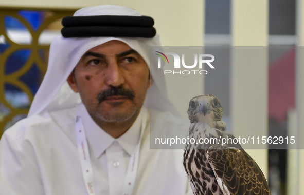 A Qatari exhibitor shows a falcon during the 8th edition of the Katara International Hunting and Falcons Exhibition 2024 (S'hail) at Katara...