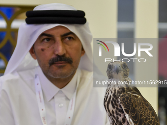 A Qatari exhibitor shows a falcon during the 8th edition of the Katara International Hunting and Falcons Exhibition 2024 (S'hail) at Katara...