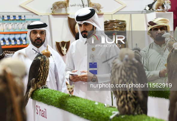 Visitors observe falcons during the 8th edition of the Katara International Hunting and Falcons Exhibition 2024 (S'hail) at Katara Cultural...