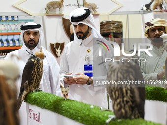 Visitors observe falcons during the 8th edition of the Katara International Hunting and Falcons Exhibition 2024 (S'hail) at Katara Cultural...