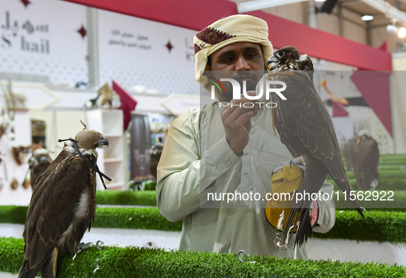 A Qatari exhibitor shows a falcon during the 8th edition of the Katara International Hunting and Falcons Exhibition 2024 (S'hail) at Katara...