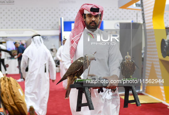 A Qatari exhibitor carries falcons during the 8th edition of the Katara International Hunting and Falcons Exhibition 2024 (S'hail) at Katara...