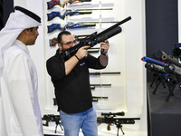 People check a hunting rifle in the guns section at the 8th edition of Katara International Hunting and Falcons Exhibition 2024 (S'hail) at...