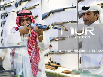 People check a hunting rifle in the guns section at the 8th edition of Katara International Hunting and Falcons Exhibition 2024 (S'hail) at...