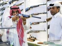 People check a hunting rifle in the guns section at the 8th edition of Katara International Hunting and Falcons Exhibition 2024 (S'hail) at...