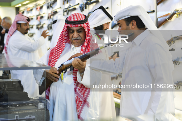 People check a hunting rifle in the guns section at the 8th edition of Katara International Hunting and Falcons Exhibition 2024 (S'hail) at...