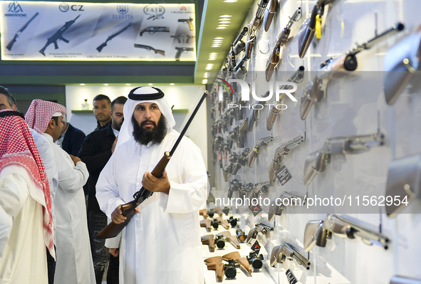 People check a hunting rifle in the guns section at the 8th edition of Katara International Hunting and Falcons Exhibition 2024 (S'hail) at...