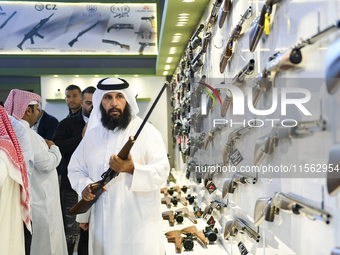 People check a hunting rifle in the guns section at the 8th edition of Katara International Hunting and Falcons Exhibition 2024 (S'hail) at...