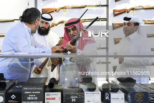 People check a hunting rifle in the guns section at the 8th edition of Katara International Hunting and Falcons Exhibition 2024 (S'hail) at...