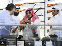 People check a hunting rifle in the guns section at the 8th edition of Katara International Hunting and Falcons Exhibition 2024 (S'hail) at...