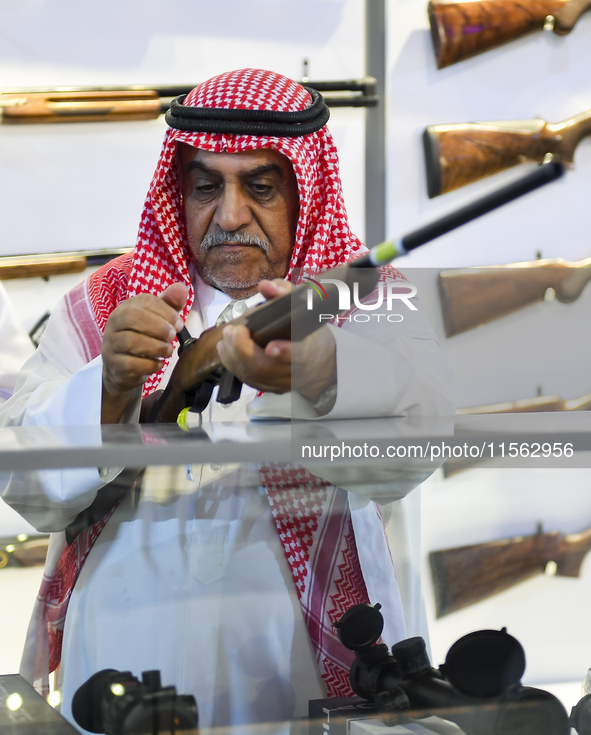 People check a hunting rifle in the guns section at the 8th edition of Katara International Hunting and Falcons Exhibition 2024 (S'hail) at...