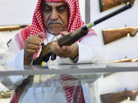 People check a hunting rifle in the guns section at the 8th edition of Katara International Hunting and Falcons Exhibition 2024 (S'hail) at...