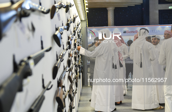 People check a hunting rifle in the guns section at the 8th edition of Katara International Hunting and Falcons Exhibition 2024 (S'hail) at...