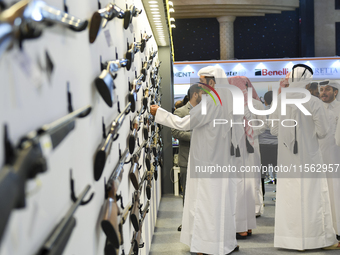 People check a hunting rifle in the guns section at the 8th edition of Katara International Hunting and Falcons Exhibition 2024 (S'hail) at...