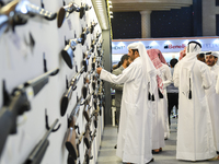 People check a hunting rifle in the guns section at the 8th edition of Katara International Hunting and Falcons Exhibition 2024 (S'hail) at...