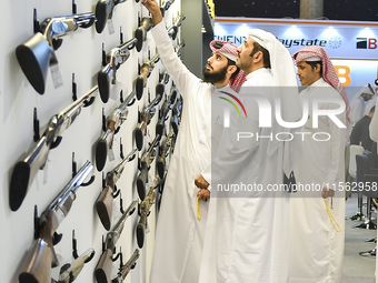 People check a hunting rifle in the guns section at the 8th edition of Katara International Hunting and Falcons Exhibition 2024 (S'hail) at...