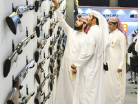 People check a hunting rifle in the guns section at the 8th edition of Katara International Hunting and Falcons Exhibition 2024 (S'hail) at...